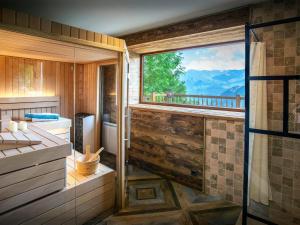 a bathroom with a shower and a large window at Chalet Bendo - OVO Network in Villarembert
