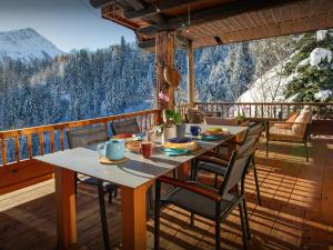 a table and chairs on a deck with a view at Chalet Bendo - OVO Network in Villarembert