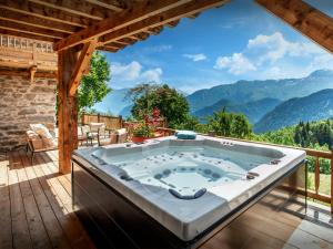 a hot tub on a deck with a view of mountains at Chalet Bendo - OVO Network in Villarembert