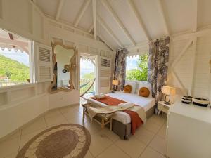 a bedroom with a bed and a large window at Villa Altaïa - Sea View & Infinity Pool in Les Trois-Îlets +59 photos