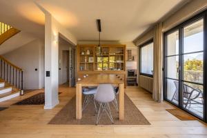 a dining room with a wooden table and chairs at Vue exceptionnelle sur lac d'Annecy et Montagnes in Menthon-Saint-Bernard