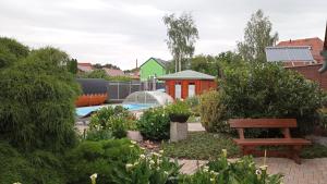 a garden with a bench and a swimming pool at Ferienhäuser Radebeul "Blick Spitzhaus" in Radebeul