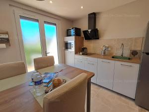 a kitchen with a wooden table and a counter top at Gîte Du Côté de Chez Souesmes in Souesmes