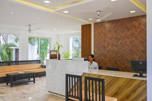 a woman sitting at a counter in a lobby at Misty Lake Resorts Munnar By Sylora Hotels in Munnar +157 photos