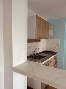 a white kitchen with a sink and a stove at Adele Hotel in Ríohacha