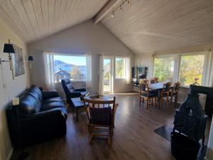 a living room with a couch and a table and chairs at Færøya 49 in Nekkøyane