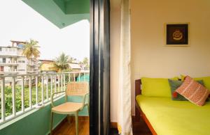 a living room with a couch and a balcony at Odd Table-Social Homestay in Mandrem