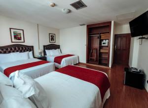 a hotel room with two beds and a television at Miraflores Colon Hotel in Lima