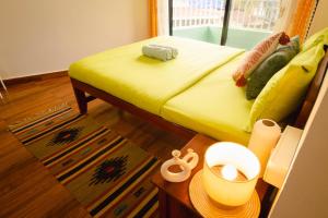 a bedroom with a bed with yellow sheets and a table at Odd Table-Social Homestay in Mandrem +79 photos