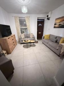 a living room with two couches and a tv at Cosy corner in Sligo