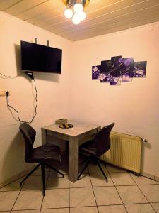 a table with two chairs and a television on a wall at Villa mit Garten 4 Personen in Nuremberg
