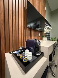 a counter with a coffee maker and cups on it at Park Plaza Lodge in Los Angeles