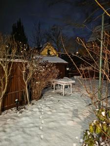 a bench sitting in the snow at night at Villa mit Garten 4 Personen in Nuremberg +7 photos