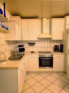 a kitchen with white cabinets and a stove top oven at Villa mit Garten 4 Personen in Nuremberg