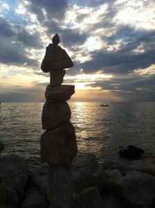 a stack of rocks sitting on top of the ocean at Apartments Jurišević in Umag