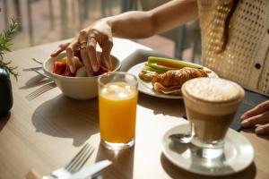 a table with a plate of food and a glass of orange juice at Catalonia Molina Lario in Málaga
