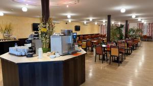 ein Restaurant mit Bar, Tischen und Stühlen in der Unterkunft G&K Hotel in Guntramsdorf