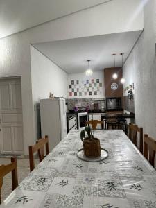 a dining room and kitchen with a table and chairs at Casa Centro de Caraguatatuba in Caraguatatuba