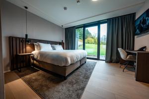 a bedroom with a bed and a desk and a window at Anatura Hotel Luxembourg in Weiswampach +101 photos