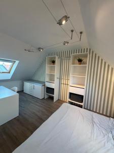 a bedroom with a bed and shelves in a room at Maison port guillaume in Dives-sur-Mer