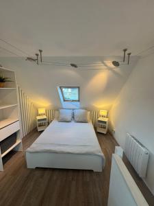 a bedroom with a white bed and two night stands at Maison port guillaume in Dives-sur-Mer