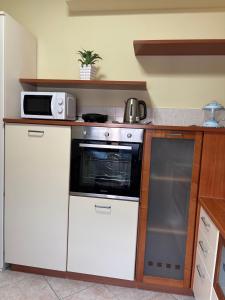 a kitchen with a white stove and a microwave at Casa Debby in Serravalle Scrivia