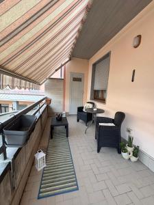a patio with a wooden roof with a table and chairs at Casa Debby in Serravalle Scrivia