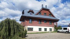 a large house with a roof on top of it at Vila Araya Mlynica in Mlynica