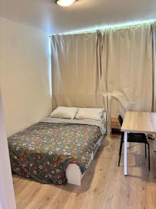 a small bed in a room with a table at Location chambre idéal travailleur étudiant Evry 1 personne in Courcouronnes