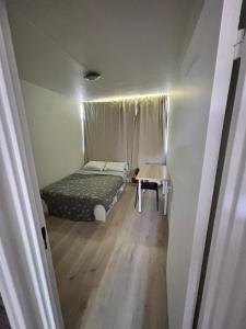 a small bedroom with a bed and a table at Location chambre idéal travailleur étudiant Evry 1 personne in Courcouronnes