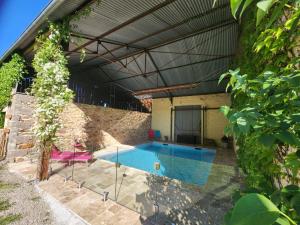 a swimming pool in the backyard of a house at La Source Du Bonheur Chambres et Table d'Hôtes in Rieupeyroux