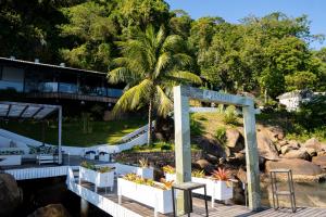 a boardwalk with tables and chairs and a palm tree at Pousada Papiro Boutique in Abraão