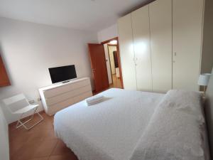 a bedroom with a white bed and a desk at Da Luca in Càbras