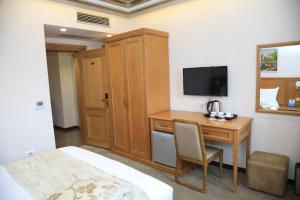 a hotel room with a desk and a television at HOTEL BOCA Center in Tirana
