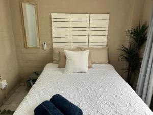 a bed with two pillows on it in a bedroom at Ocean Village - No Sea View in Amanzimtoti