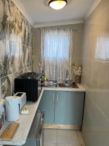 a small kitchen with a sink and a window at Ocean Village - No Sea View in Amanzimtoti
