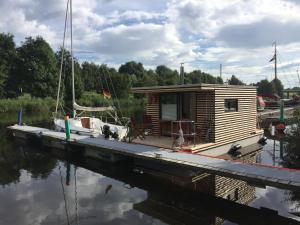 eine kleine Hütte auf einem Boot im Wasser in der Unterkunft Hausboot Resort Nordseeküste in Wilhelmshaven