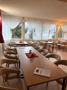 a room with tables and chairs and windows at Pensiunea Alpina in Malaia