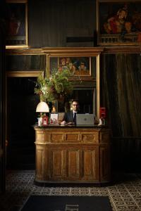 a man sitting at a desk with a laptop at Hotel Les Bains Paris in Paris +140 photos
