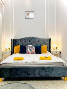 a bedroom with a blue bed with yellow pillows at Sweet cozy studio ultracentral in Cluj-Napoca