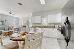 a kitchen and living room with a table and a refrigerator at Topsail Village #511 - Beach Moon in Santa Rosa Beach