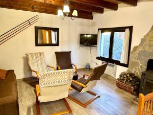 a living room with three chairs and a fireplace at Casa Enry in Alcalá de la Selva