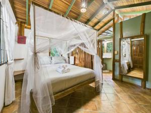 a bedroom with a bed with a canopy at Pachamama Bungalows & Surfcamp - Santa Teresa in Carmen