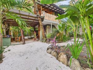 a house with a courtyard with trees and plants at Pachamama Bungalows & Surfcamp - Santa Teresa in Carmen