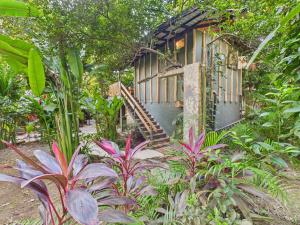 a small house with a staircase in a garden at Pachamama Bungalows & Surfcamp - Santa Teresa in Carmen +72 photos
