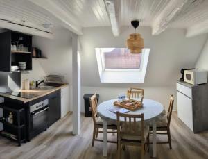 a kitchen with a table and chairs in a kitchen at Escale Im Elsass in Mutzig