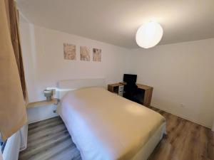 a small bedroom with a white bed and a lamp at Escale Im Elsass in Mutzig