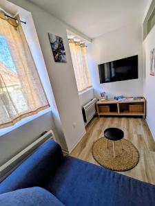 a living room with a blue couch and a tv at Escale Im Elsass in Mutzig