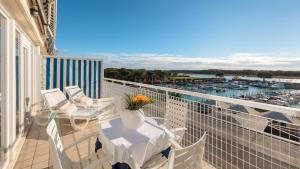 a balcony with a table and chairs and a marina at Hotel Marina Uno in Lignano Sabbiadoro
