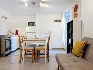 a kitchen with a table and chairs in a room at Coeur de pierre in Vallon-Pont-dʼArc